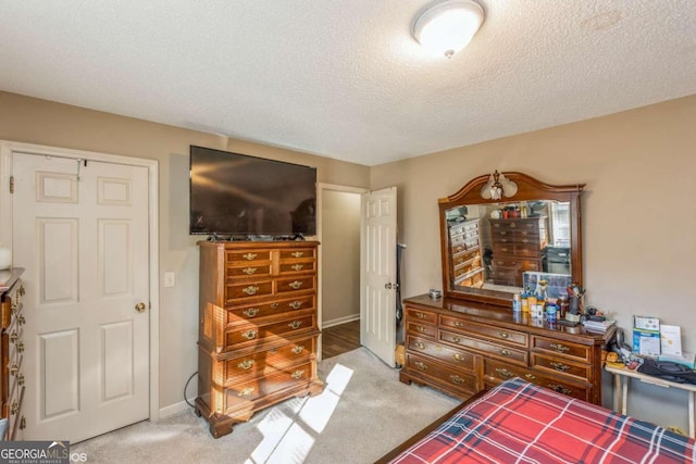 carpeted bedroom with a textured ceiling and a closet