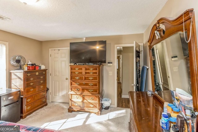 carpeted bedroom with a textured ceiling and a closet