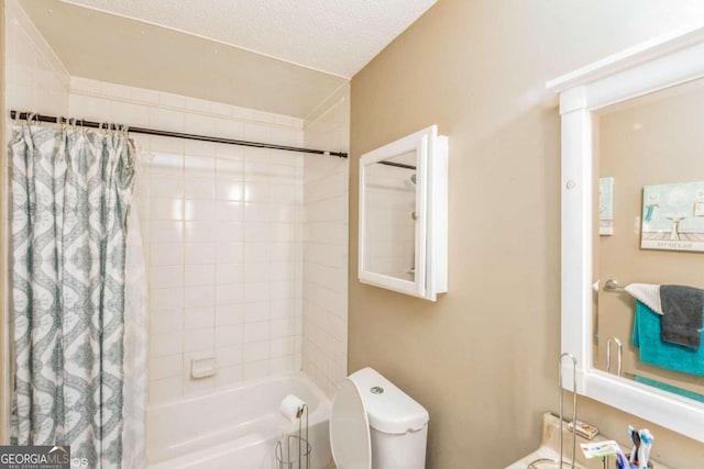 bathroom featuring shower / bath combo with shower curtain, a textured ceiling, and toilet