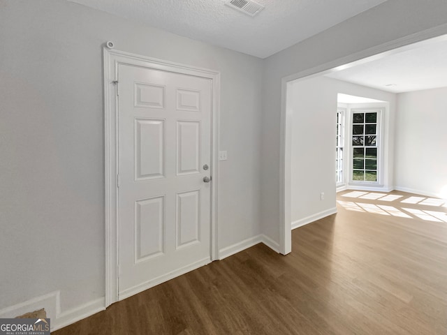 unfurnished room featuring hardwood / wood-style floors and a textured ceiling