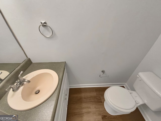 bathroom with vanity, hardwood / wood-style flooring, and toilet