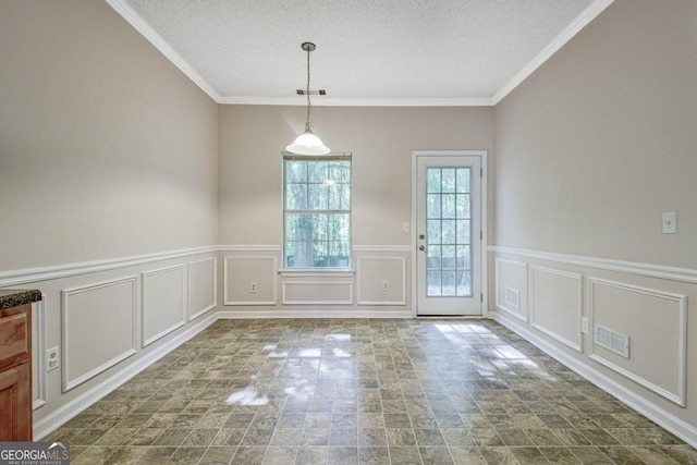 unfurnished dining area with crown molding and a textured ceiling