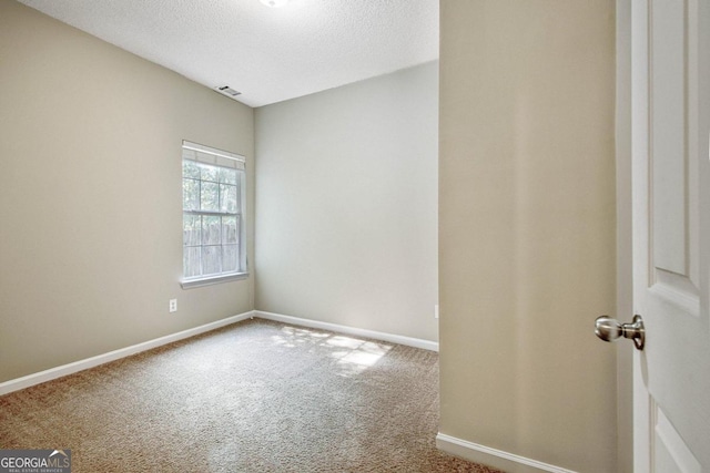 carpeted empty room featuring a textured ceiling