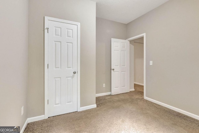 unfurnished bedroom with carpet flooring and a textured ceiling