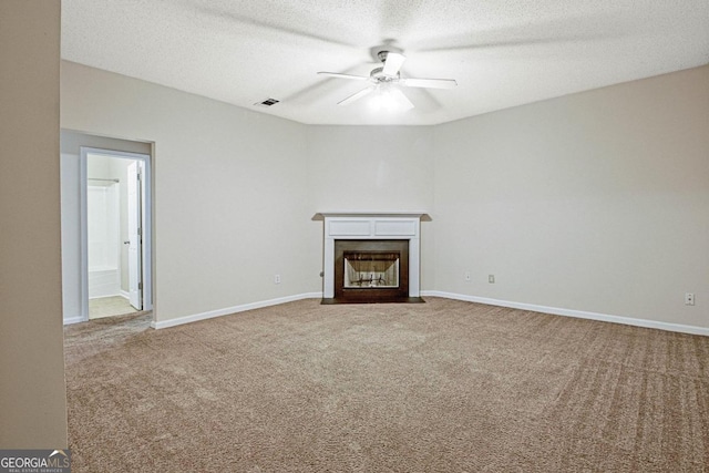 unfurnished living room featuring carpet, a textured ceiling, and ceiling fan