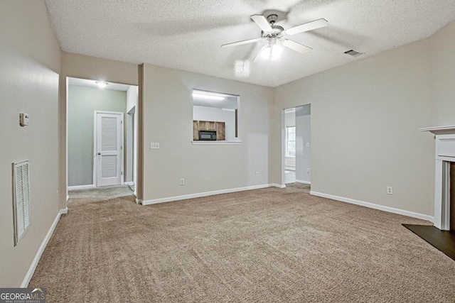 unfurnished living room with a textured ceiling, carpet floors, and ceiling fan