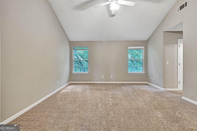 carpeted spare room featuring ceiling fan, a textured ceiling, and vaulted ceiling