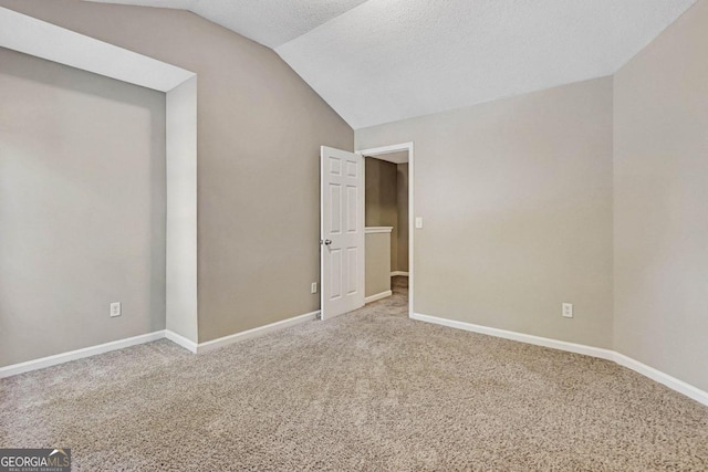 unfurnished room with lofted ceiling, carpet, and a textured ceiling