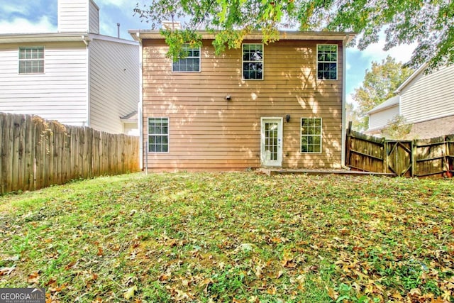 rear view of house featuring a lawn