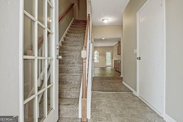 interior space featuring a textured ceiling and carpet floors