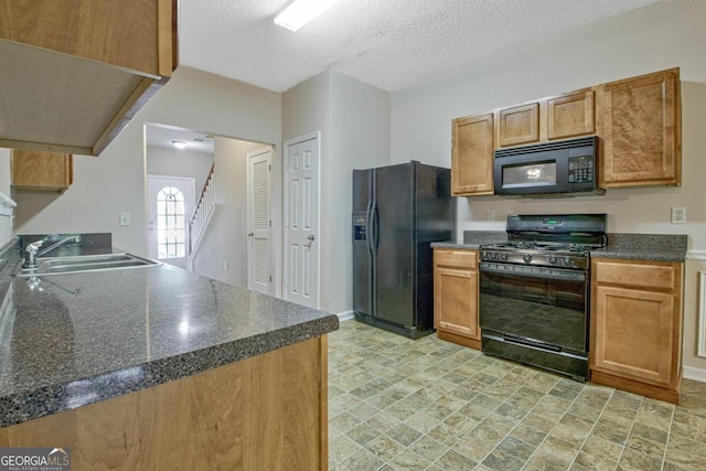 kitchen with a textured ceiling, black appliances, and sink