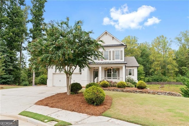 view of front of home with a front lawn, covered porch, and a garage