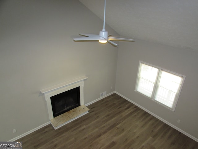 unfurnished living room featuring dark wood-type flooring, ceiling fan, and vaulted ceiling