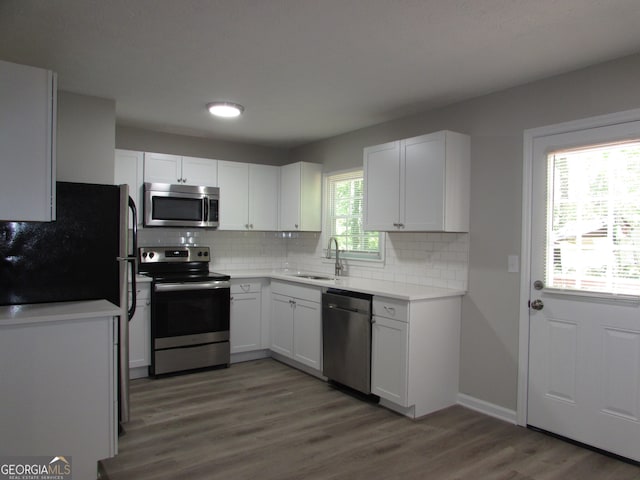 kitchen featuring white cabinets, stainless steel appliances, and a wealth of natural light