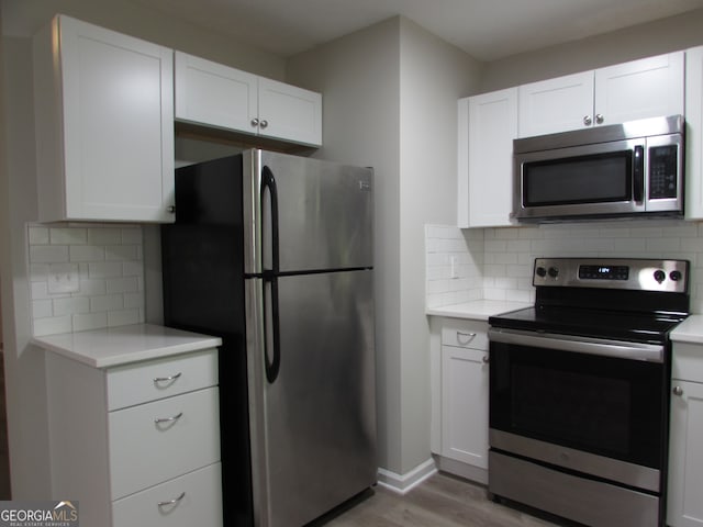 kitchen with white cabinetry, backsplash, and appliances with stainless steel finishes