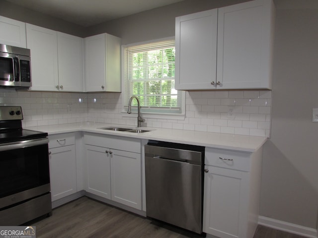 kitchen featuring sink, white cabinetry, stainless steel appliances, and dark hardwood / wood-style floors