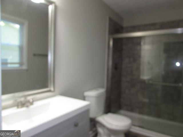 bathroom with toilet, an enclosed shower, and vanity