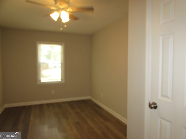 spare room featuring dark wood-type flooring and ceiling fan