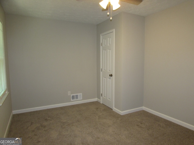 carpeted empty room with ceiling fan and a textured ceiling