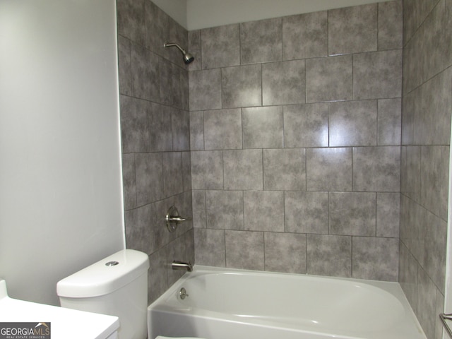 full bathroom featuring vanity, tiled shower / bath combo, and toilet