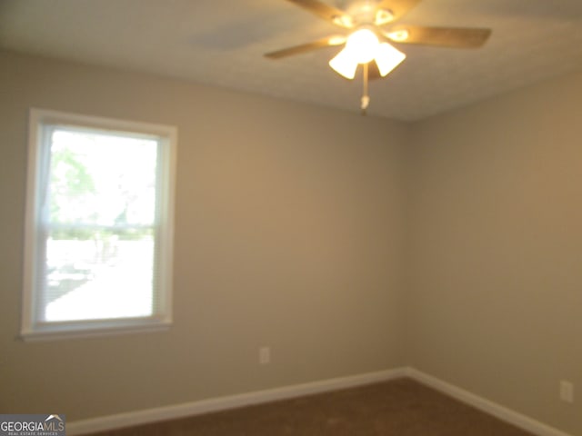 carpeted spare room with ceiling fan