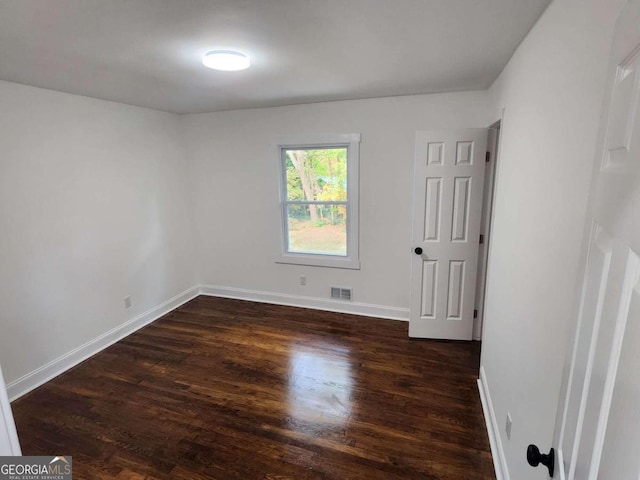 unfurnished room featuring dark wood-type flooring