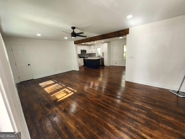 unfurnished living room with ceiling fan and dark hardwood / wood-style flooring