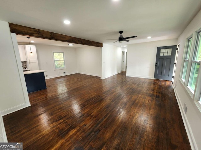 unfurnished living room featuring ceiling fan, beamed ceiling, and dark hardwood / wood-style flooring