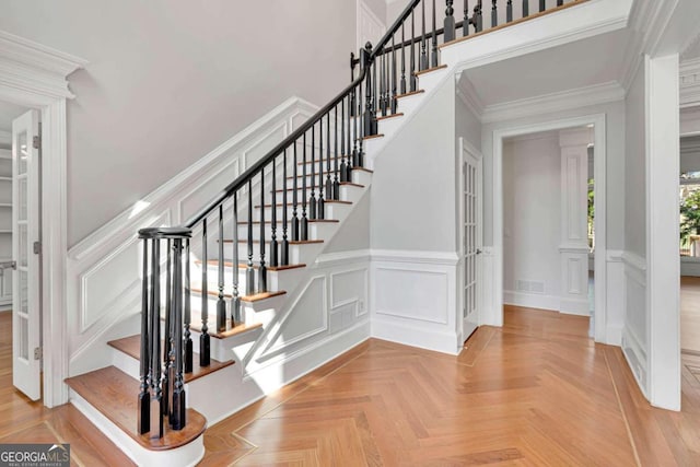 stairway with parquet flooring and ornamental molding