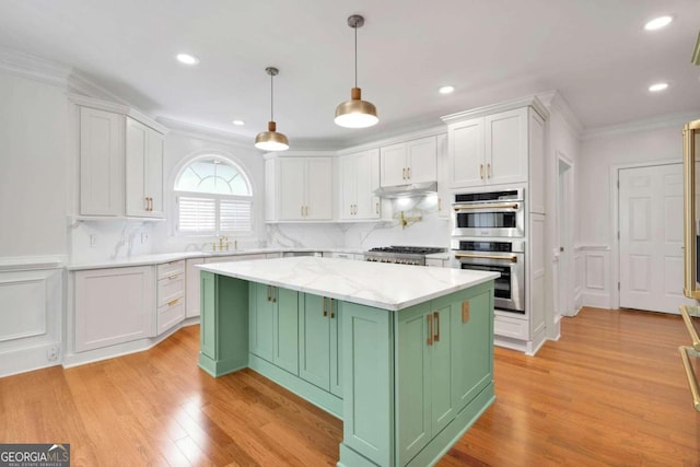 kitchen with green cabinetry, a kitchen island, decorative light fixtures, white cabinets, and light hardwood / wood-style flooring