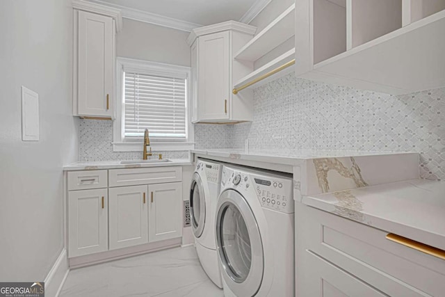 laundry room with ornamental molding, sink, separate washer and dryer, and cabinets