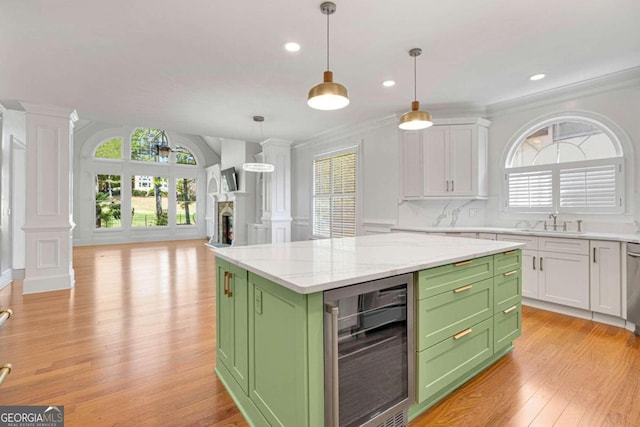 kitchen with white cabinets, beverage cooler, a kitchen island, light hardwood / wood-style flooring, and green cabinetry