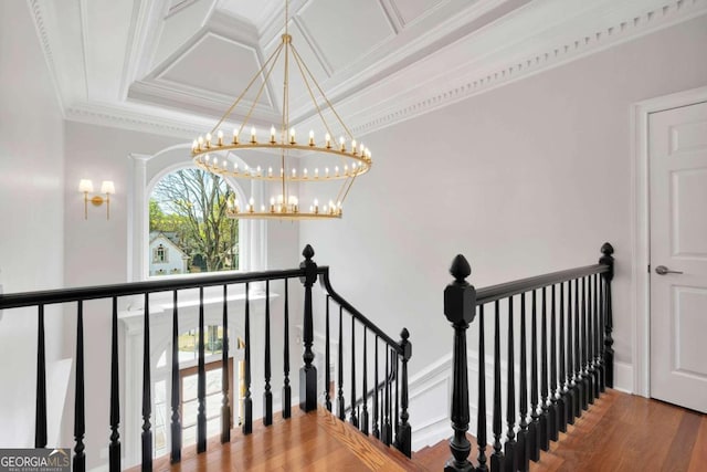 stairs featuring a notable chandelier, crown molding, and hardwood / wood-style flooring