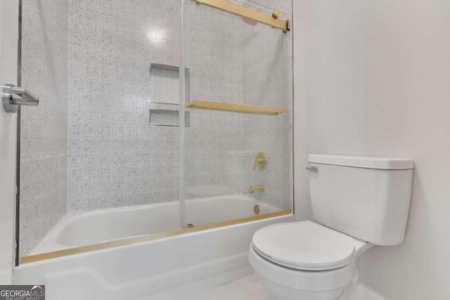 bathroom featuring enclosed tub / shower combo and toilet