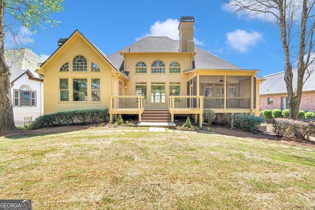 rear view of house with a deck and a lawn