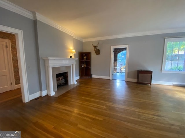 unfurnished living room featuring crown molding, wood-type flooring, and plenty of natural light