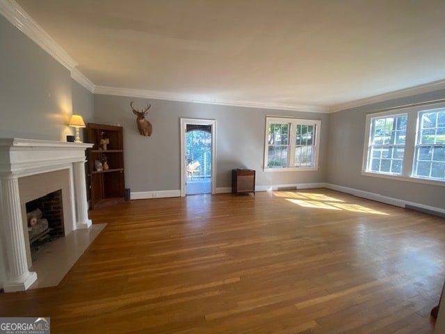 unfurnished living room featuring ornamental molding and hardwood / wood-style flooring