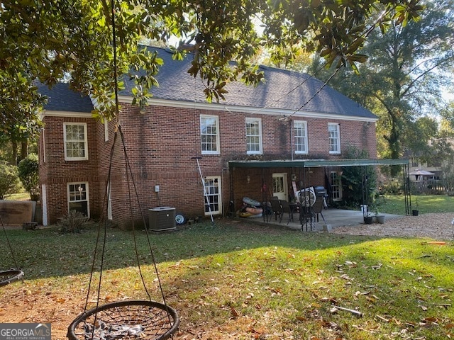 rear view of house with a patio, a yard, and central AC unit