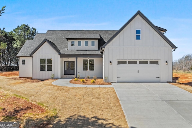 modern farmhouse style home featuring french doors, a shingled roof, concrete driveway, an attached garage, and board and batten siding