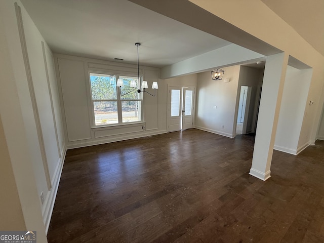 unfurnished dining area featuring dark hardwood / wood-style flooring and a chandelier