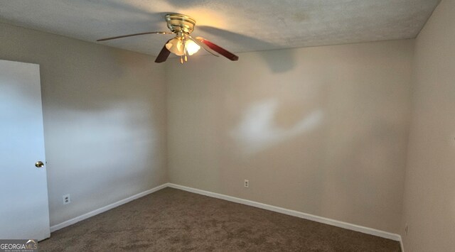 carpeted spare room featuring a textured ceiling and ceiling fan