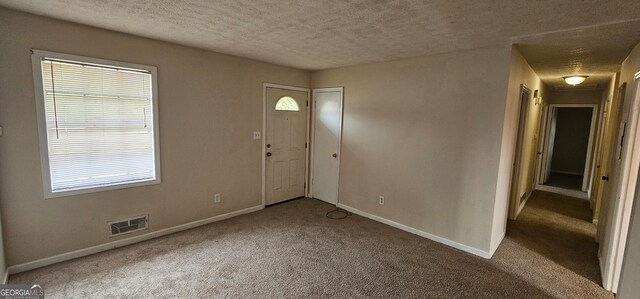 carpeted entryway featuring a textured ceiling