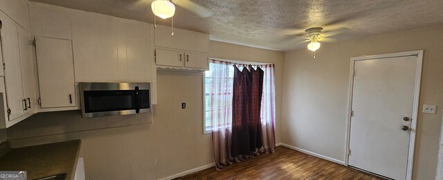 kitchen featuring dark wood-type flooring, ceiling fan, a healthy amount of sunlight, and white cabinets