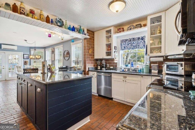 kitchen featuring a wealth of natural light, sink, appliances with stainless steel finishes, and a kitchen island