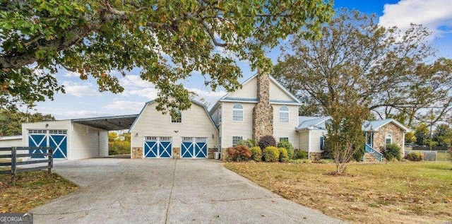 front facade with a front yard, an outbuilding, and a carport