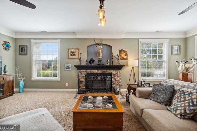 living room with a stone fireplace, crown molding, carpet, and a wealth of natural light