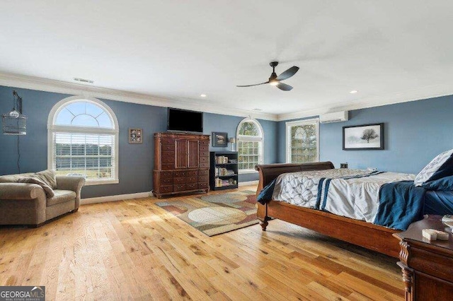 bedroom with a wall unit AC, ceiling fan, crown molding, and light hardwood / wood-style floors