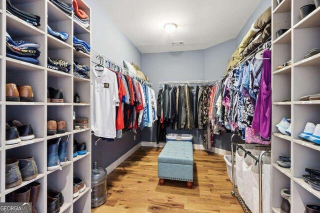 walk in closet with light hardwood / wood-style flooring