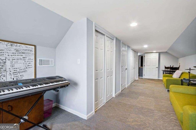 corridor with lofted ceiling and light colored carpet