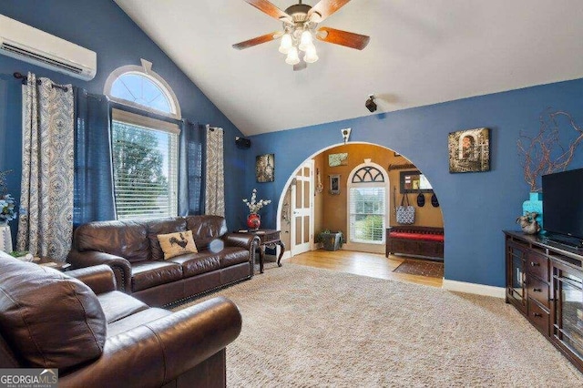 carpeted living room featuring a wall mounted AC, ceiling fan, and plenty of natural light